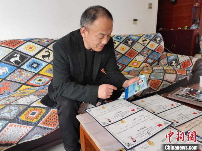 刘振三向记者介绍儿子刘子旭的获奖情况。　杨英琦 摄