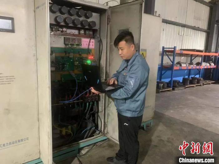 周胜勇带着笔记本电脑，穿梭于大型机器间为设备“把脉”。　上海市工商联 摄