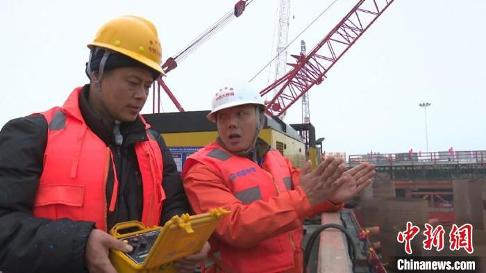 胡建丰正在与工友商讨施工方案。　刘鸿鹤 摄