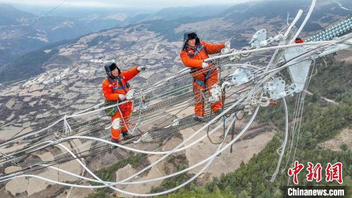电力工人曾坤银和熊志伟正在进行高空作业。　卢忠东 摄