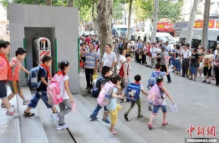 资料图：小学门外等待学生放学的家长们。中新社发 张畅 摄