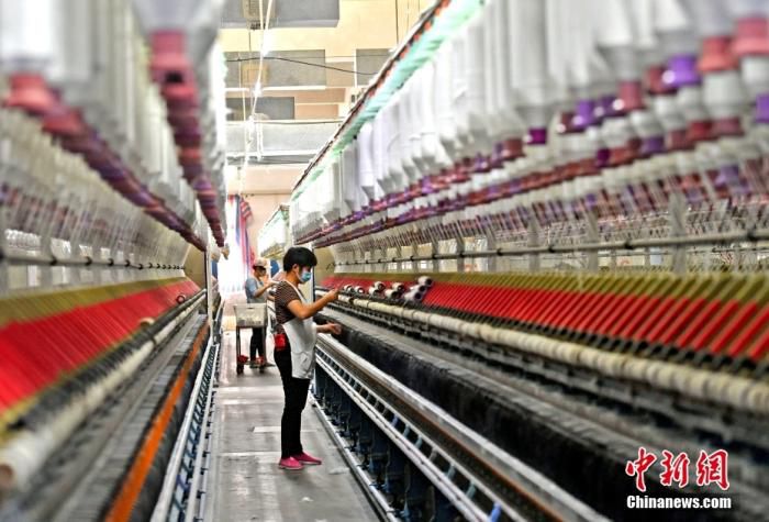 图为农村外出务工人员在福建泉州一纺织厂流水线作业。（资料图片） 中新社记者 王东明 摄