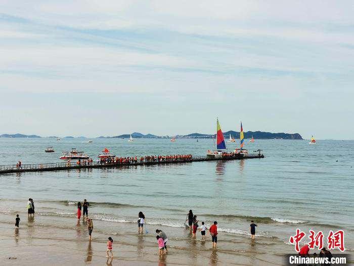 资料图：图为山东蓬莱海水浴场在假期里迎来众多游客赶海。　赵晓 摄