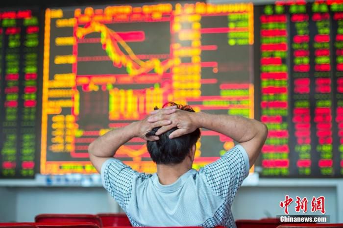 资料图：海口某证券营业部的股民关注大盘走势。中新社记者 骆云飞 摄