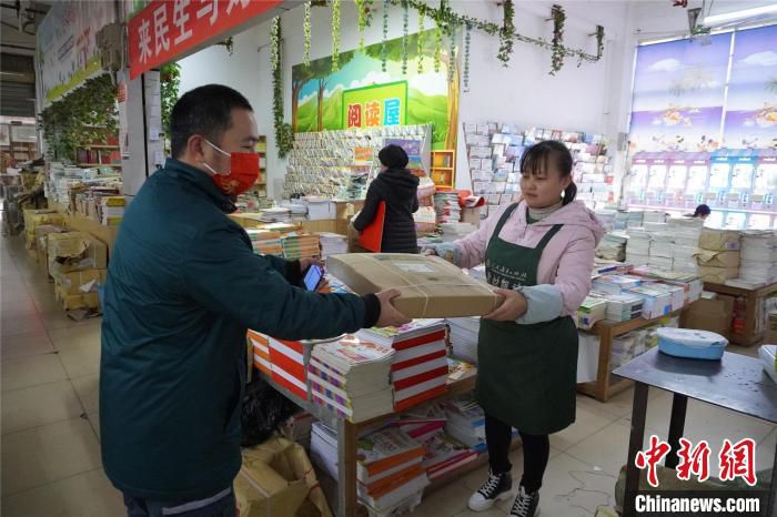 快递员韦海在广西柳州市屏山大道书市文化广场配送快递。　何芳芸 摄
