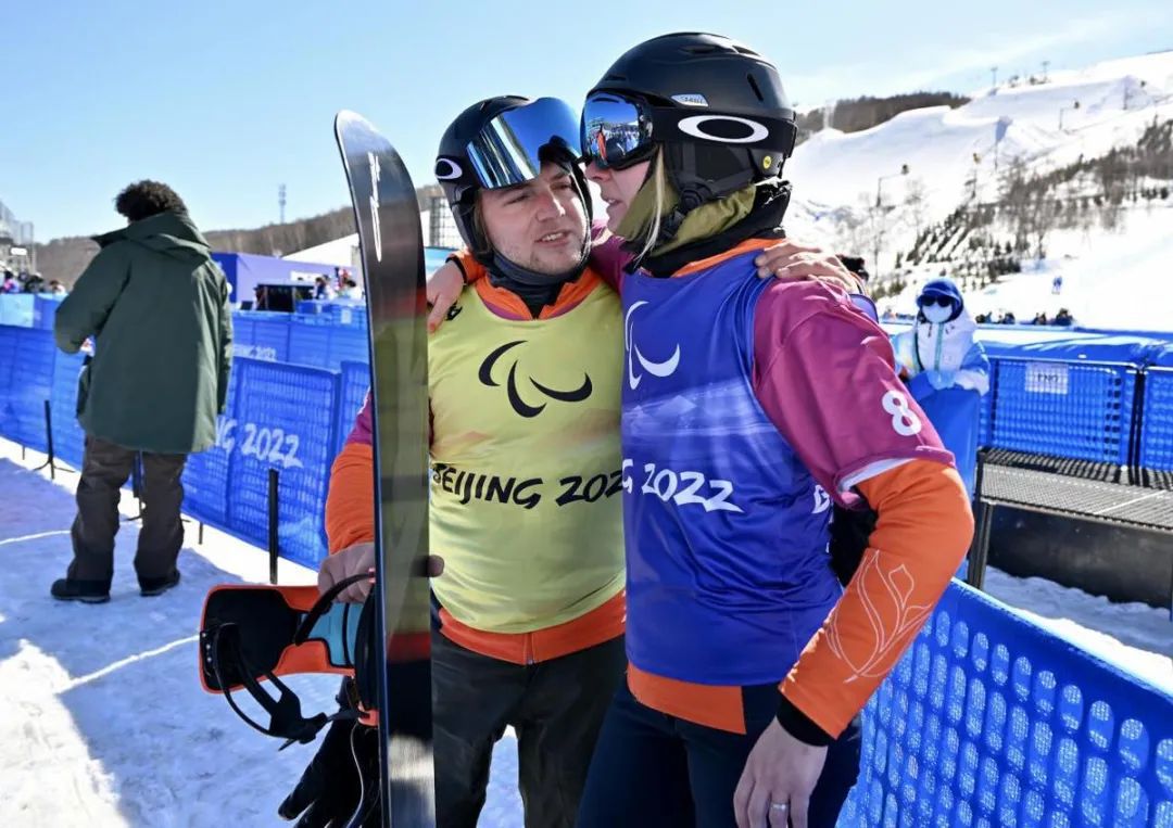 福斯(左)和莉萨在崇礼云顶滑雪公园完成男子和女子残奥单板滑雪比赛后互相鼓励。中国日报记者 魏晓昊 摄
