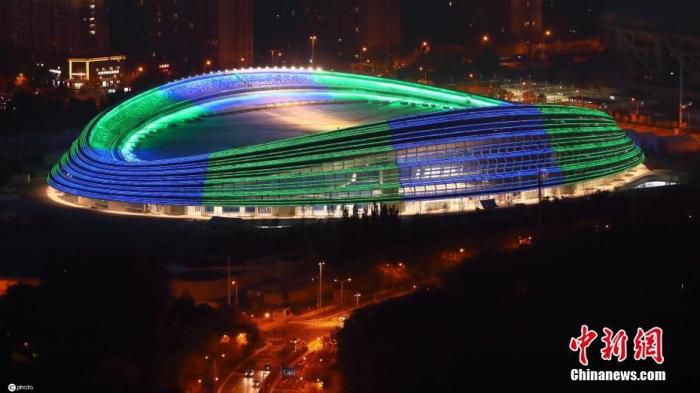 图为从北京奥林匹克塔顶观景上俯瞰国家速滑馆(“冰丝带”)夜景，流动的建筑夜景灯线条勾画一条条“冰丝带”。图片来源：ICphoto