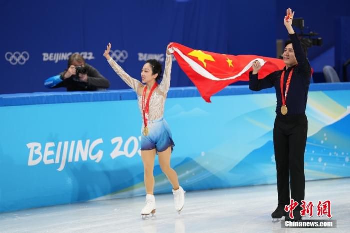 2月19日，中国组合隋文静(左)/韩聪在比赛后手举五星红旗滑行。当日，北京2022年冬奥会花样滑冰双人滑自由滑比赛在首都体育馆举行，中国组合隋文静/韩聪夺得双人滑冠军。 中新社记者 崔楠 摄