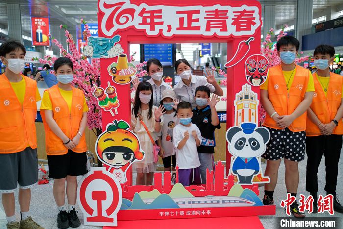 图为重庆北站候车大厅,旅客与铁路青年志愿者们在成渝铁路开通运营70周年的纪念展板前合影留念。 中新社记者 何蓬磊 摄 图为重庆北站候车大厅,旅客与铁路青年志愿者们在成渝铁路开通运营70周年的纪念展板前合影留念。 中新社记者 何蓬磊 摄