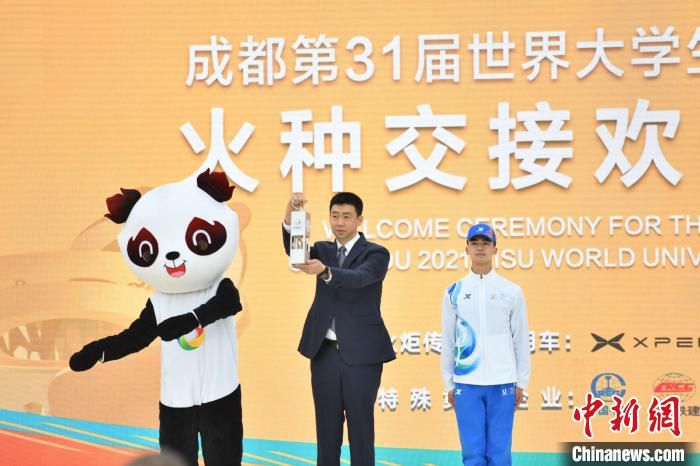 国际大体联副主席申震(中)将今年1月在首届大运会举办城市意大利都灵采集的火种递交给成都。　张浪 摄