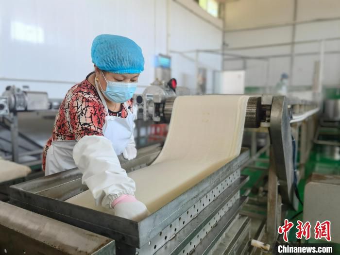 图为三河市征亮食品有限公司生产车间，现代化的泼片生产线高速运转。　刘伟 摄