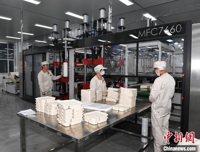 一条条自动化流水上，以玉米淀粉为原材料的环保餐盒经过压模成型被生产出来。　郑村镇供图