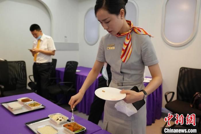 图为一名乘务员正在试吃“飞机餐”。　张哲 摄