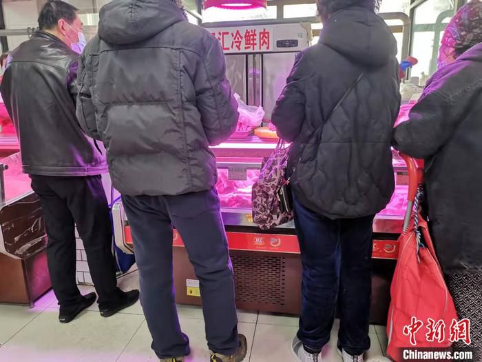 居民在猪肉摊前购买猪肉。 中新网记者 谢艺观 摄