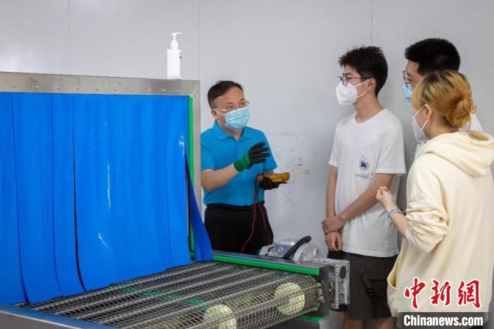何成教授在与团队成员交流设备使用事项。　上海第二工业大学 摄