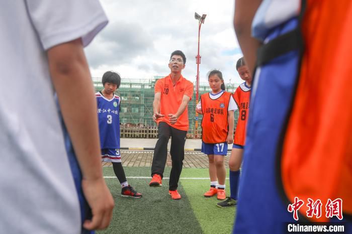 5月28日，寻乌县澄江中心小学足球场，晨曦女足的教练赖文亮(中)在球队训练结束后进行点评指导。　刘力鑫 摄