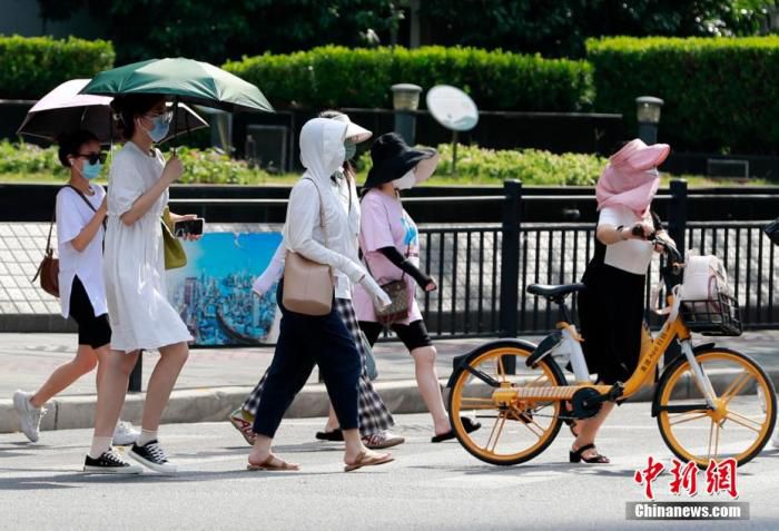 路人“各显神通”躲避炙热的阳光。 汤彦俊 摄