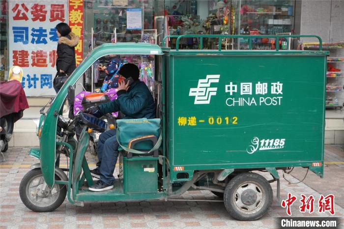 快递员韦海穿梭在大街小巷上配送快递。　何芳芸 摄