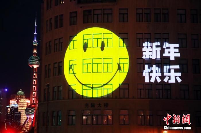 2021年12月31日晚，一张标志性的笑脸出现在上海苏州河畔的大楼外墙上，与民众一起喜迎2022年的到来。 中新社记者 汤彦俊 摄
