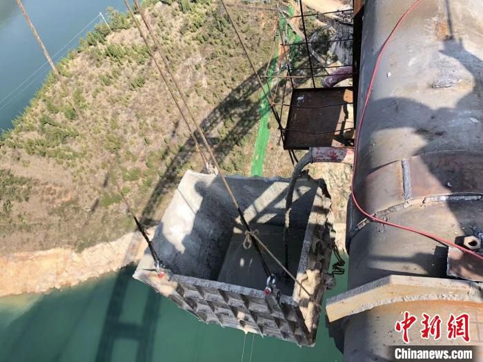 图为郑渝高铁大宁河双线大桥施工过程中，将弃渣等放入自制料斗中，防止弃渣落入大宁河。　中铁二局供图