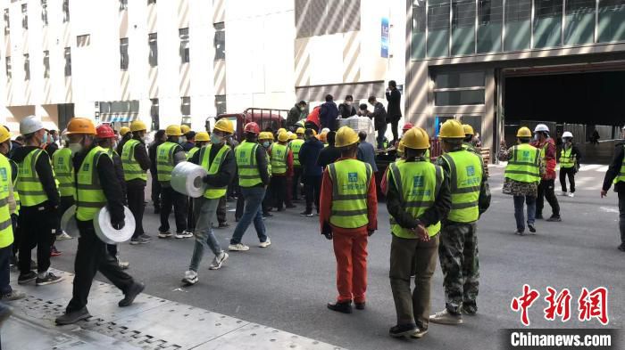 国家会展中心(上海)2号馆前，中建二局安装公司工人正在卸运物资。　中建二局供图