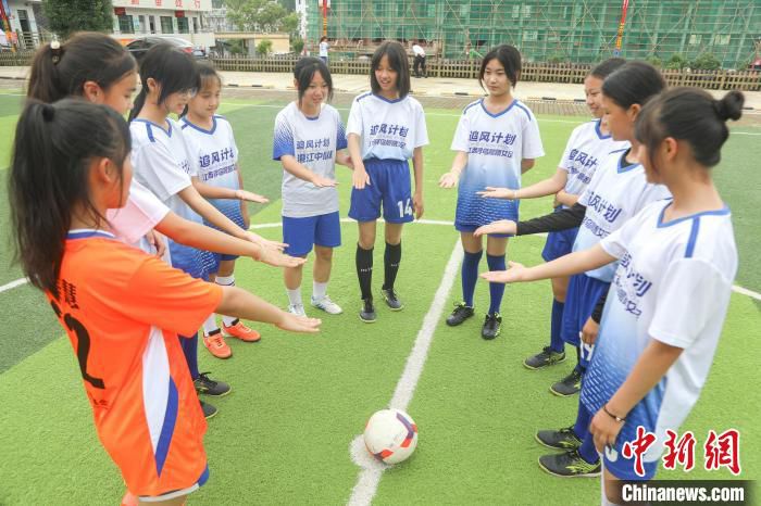 5月28日，寻乌县澄江中心小学足球场，晨曦女足的队员们在训练开始前，通过“黑白配”游戏的方式分组。　刘力鑫 摄