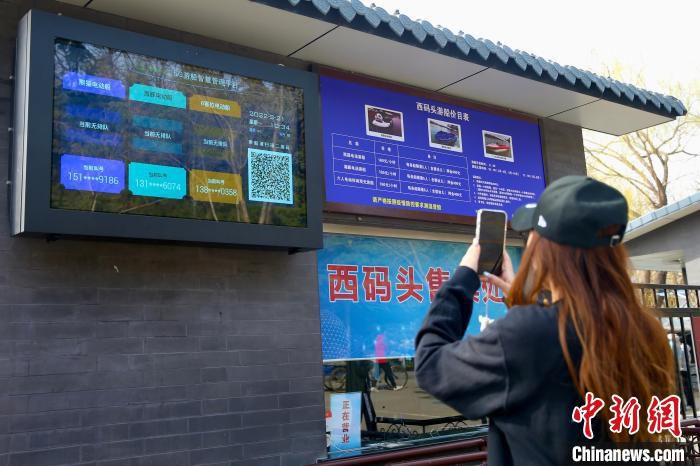 图为游客在陶然亭公园西码头扫描二维码，进行线上游船购票。　易海菲　摄