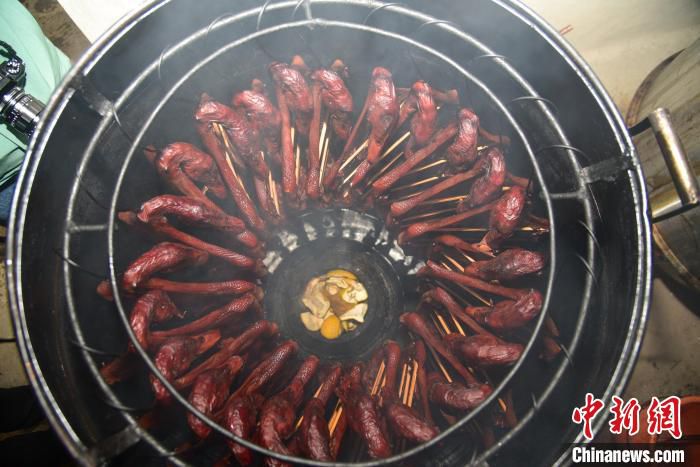 农户在底部点燃柚子皮和甘蔗为腊鸭赋予香味。　王以照 摄