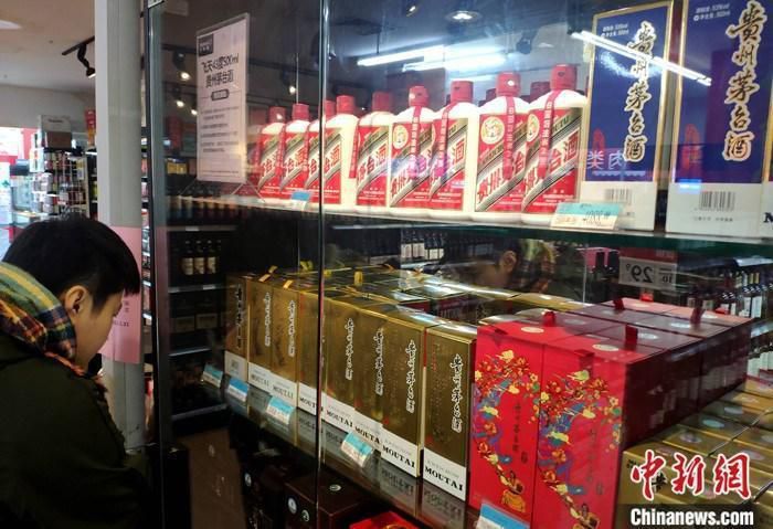 资料图：市民在福建福州的一超市贵州茅台酒专柜了解信息。 中新社记者 吕明 摄
