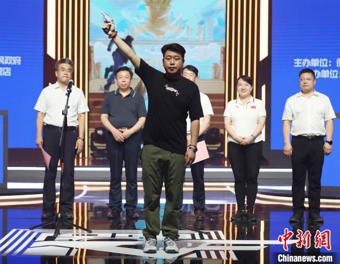 图为庞伟为比赛鸣枪助阵。　徐巧明 摄