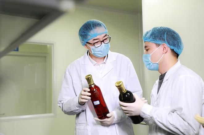 听花酒总设计师张雪峰在听花实验室与科研人员研究酒体