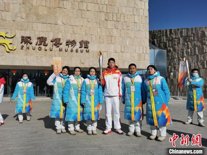 图为王政在火炬传递点与志愿者合影。　王政供图