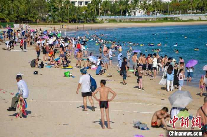 资料图：众多游客在三亚大东海旅游景区海滩享受碧海蓝天 骆云飞 摄
