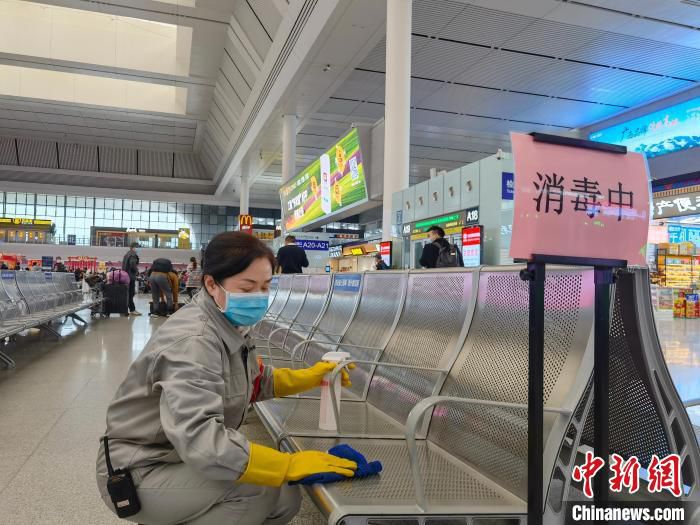 图为敖存娜对候车室座椅进行消毒擦抹。　杨桂莲 摄