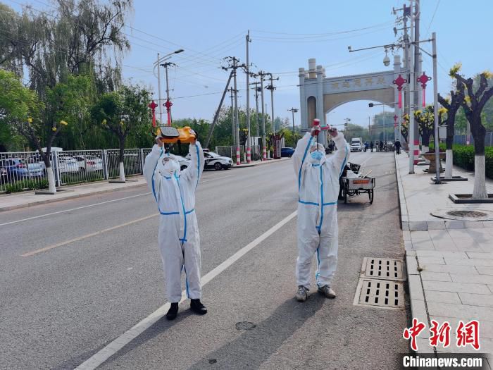 图为北京房山供电公司窦店供电所一线运维人员在窦店封控区巡视测温线路，保障地区供电可靠安全。　寇承卿 摄