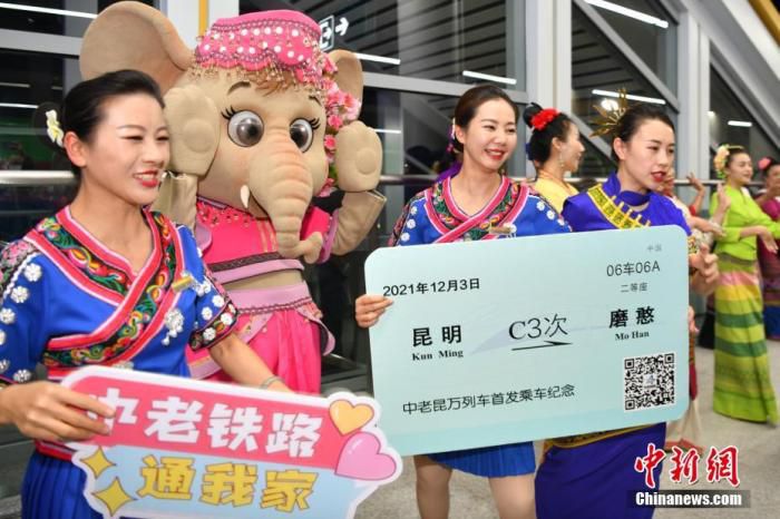2021年12月3日，中老铁路全线开通运营，西双版纳傣族自治州举行具有民族特色的欢迎仪式，迎接首批乘坐首发列车的旅客抵达西双版纳景洪市。图为列车员在西双版纳站与当地迎宾合影。 中新社记者 刘冉阳 摄