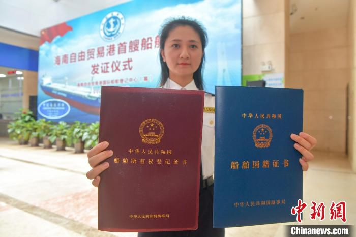 图为洋浦海事局的工作人员展示“中国洋浦港”的首艘国际登记船舶所有权登记证书和《船舶国籍证书》。　骆云飞 摄