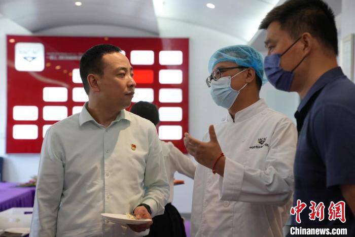 图为机组人员正在与厨师沟通“飞机餐”的有关事宜。　张哲 摄
