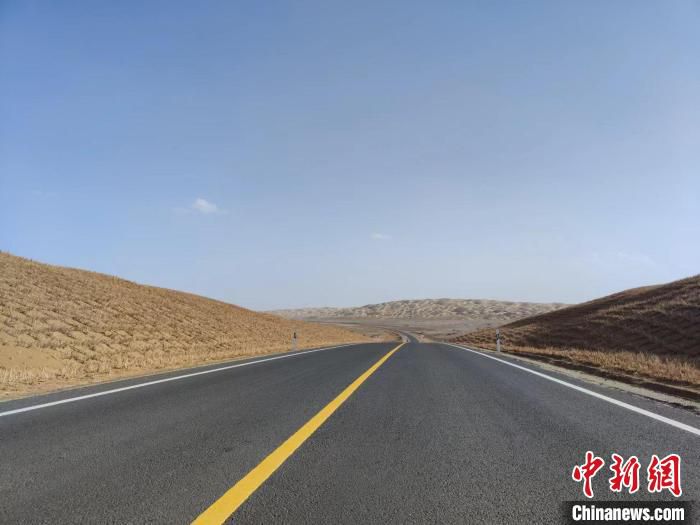 在塔克拉玛干沙漠腹地中，一条崭新而平坦的公路延伸向沙漠远方。　喇小飞 摄
