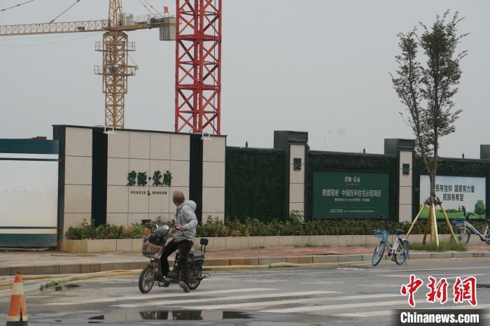 资料图：郑州北龙湖一市民路过在建楼盘。 董飞 摄 