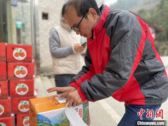 秭归橘农在物流服务站贴单。　郭晓莹 摄