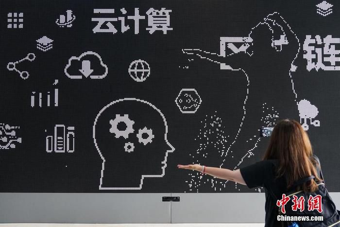 资料图：一名参观者在国家大数据(贵州)综合试验区展示中心互动性磁力翻转屏前进行体验。中新社记者 瞿宏伦 摄