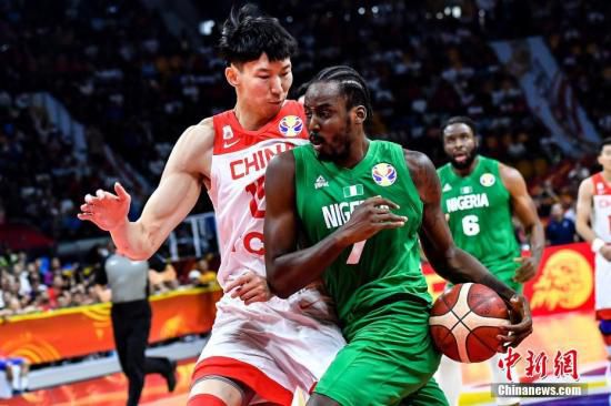 9月8日晚，中国队球员周琦(左)在比赛中防守尼日利亚球员阿米奴(中)的上篮。当晚，2019年国际篮联篮球世界杯17-32名排位赛继续进行，在广州举行的M组一场比赛中，中国(白)73比86不敌尼日利亚(绿)。中新社记者 陈骥旻 摄