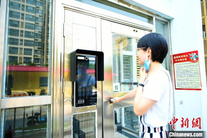 图为廊坊市安次区馨语社区居民在智能人脸门禁前刷脸进门。　杨佳琳 摄