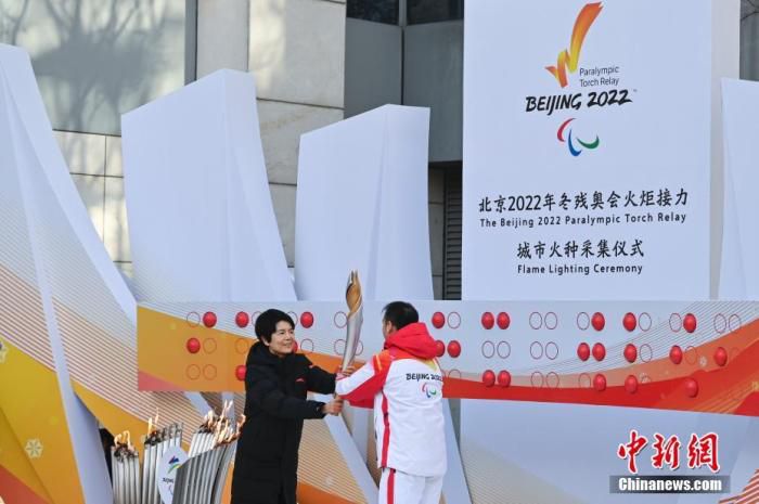 3月2日，中国残联副理事长王梅梅(左)将火种火炬交给第一棒火炬手朱鹏凯。当日，北京2022年冬残奥会火种采集仪式在中国盲文图书馆举行，采集“希望之火”。 中新社记者 张兴龙 摄