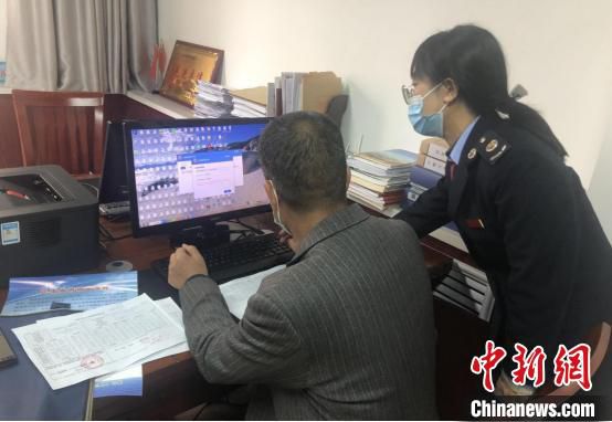 图为税务干部帮助纳税人解决涉税难题。(资料图) 甘肃省税务局供图