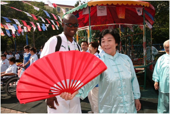 图为2008年社区居民和残奥会运动员讲解“功夫扇”。望京街道温馨家园供图