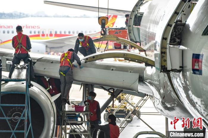 图为工作人员对澜湄航空的空客A320飞机进行高级别定检维修工作，这是首单境外飞机进境保税维修业务。　骆云飞 摄