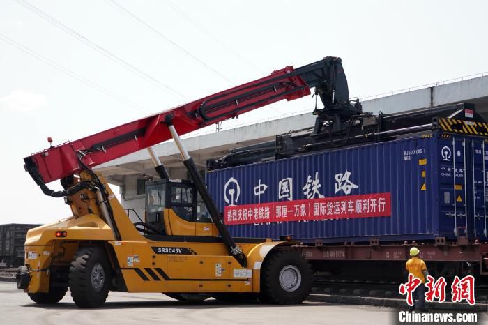 图为装卸人员正在有条不紊地指挥跨境集装箱吊装作业。　谭媛元 　摄