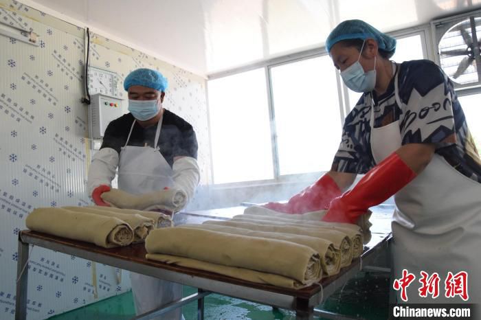 图为三河市征亮食品有限公司生产车间，一卷卷冒着热气的豆片儿新鲜出炉。　高澍 摄